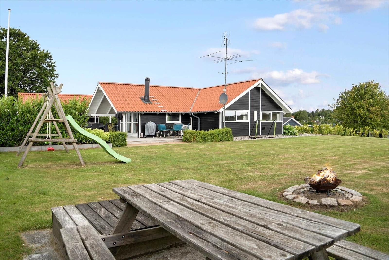 House with garden, picnic table, fire pit, and playground.