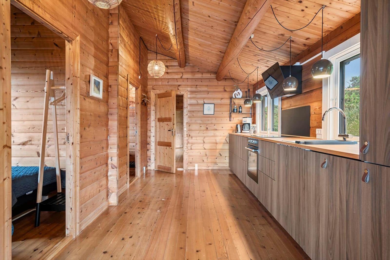 Holzhaus mit Küche, Schlafzimmer und Flur. Holzdecke, -boden und -wände.