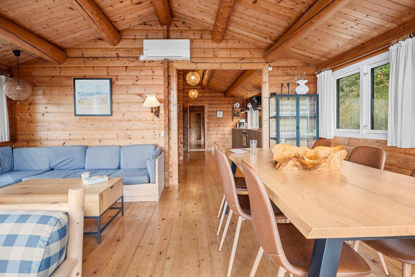 Wohn- und Essbereich mit Holzdecke, Sofa und Esstisch.