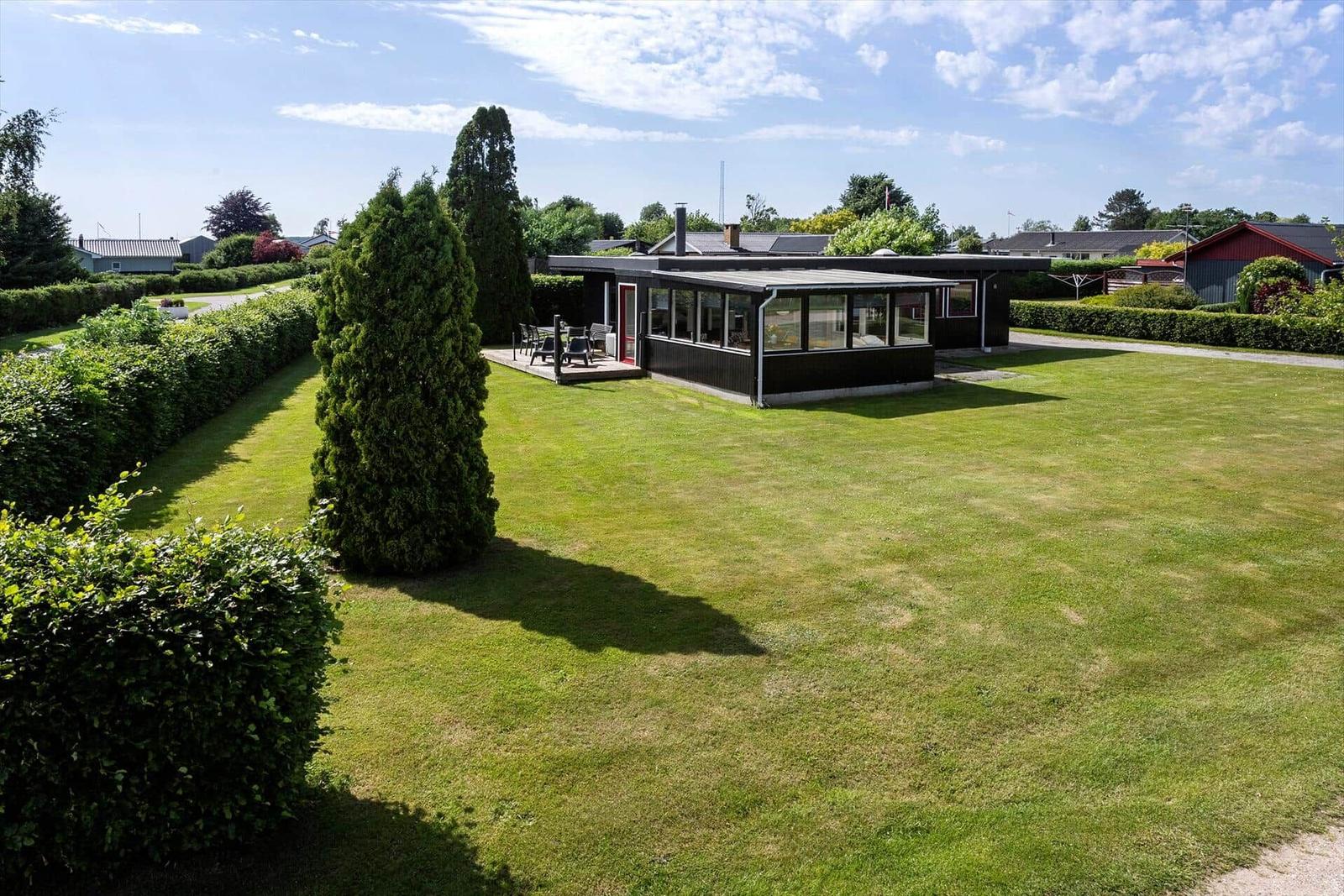 Modern villa with large garden and terrace. Surrounded by trees and hedges.