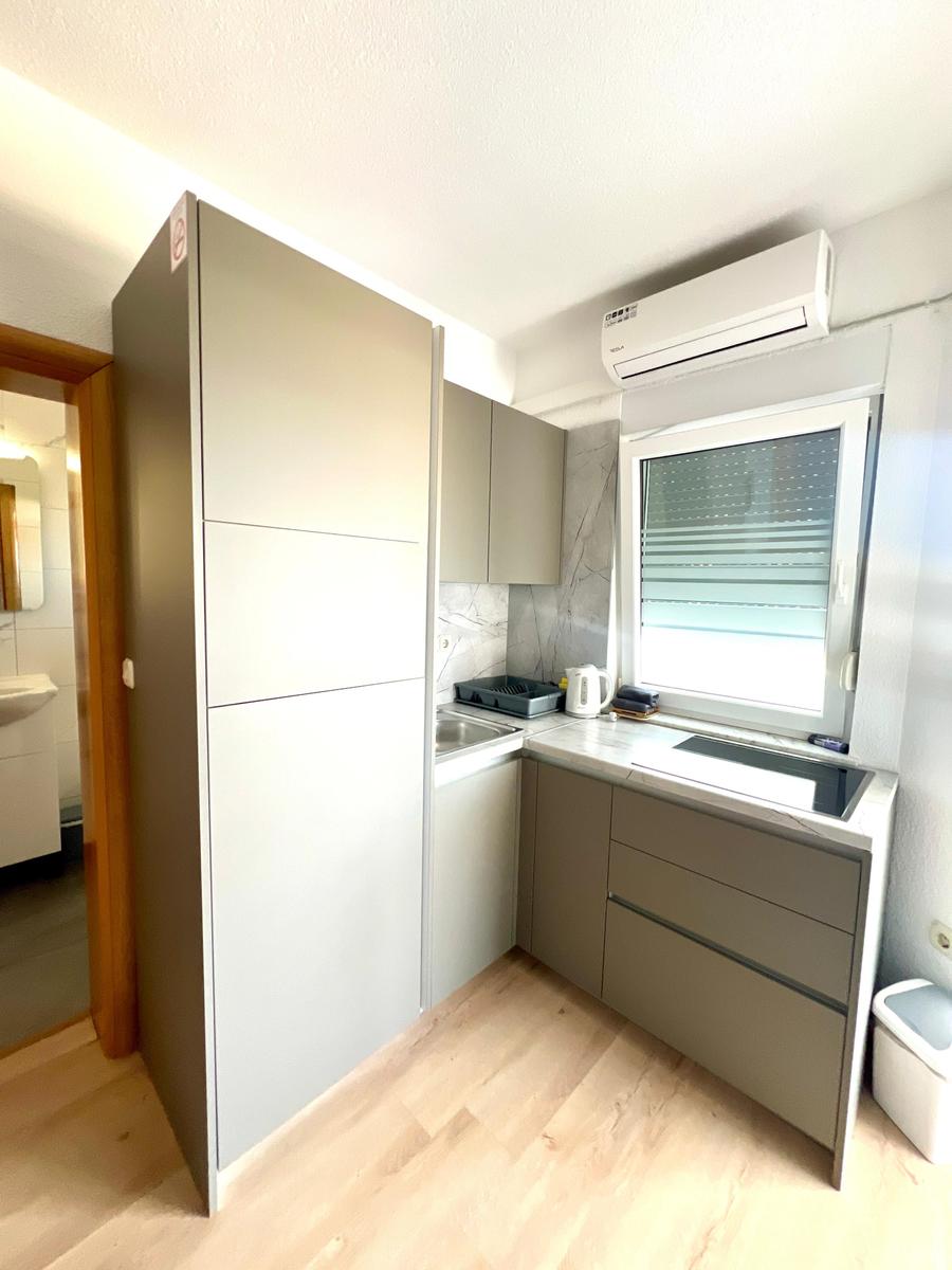 Küche mit grauen Schränken, Fenster und Küchenzeile