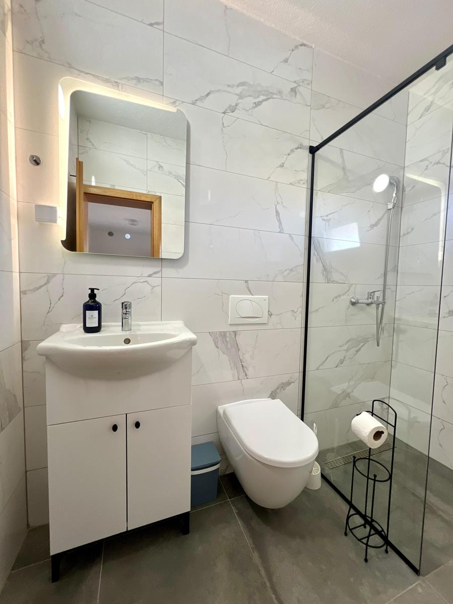 Badezimmer mit Dusche, Waschbecken und Toilette