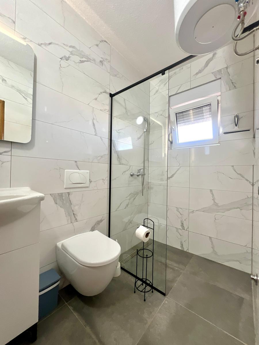 Badezimmer mit Dusche, Toilette und Waschbecken