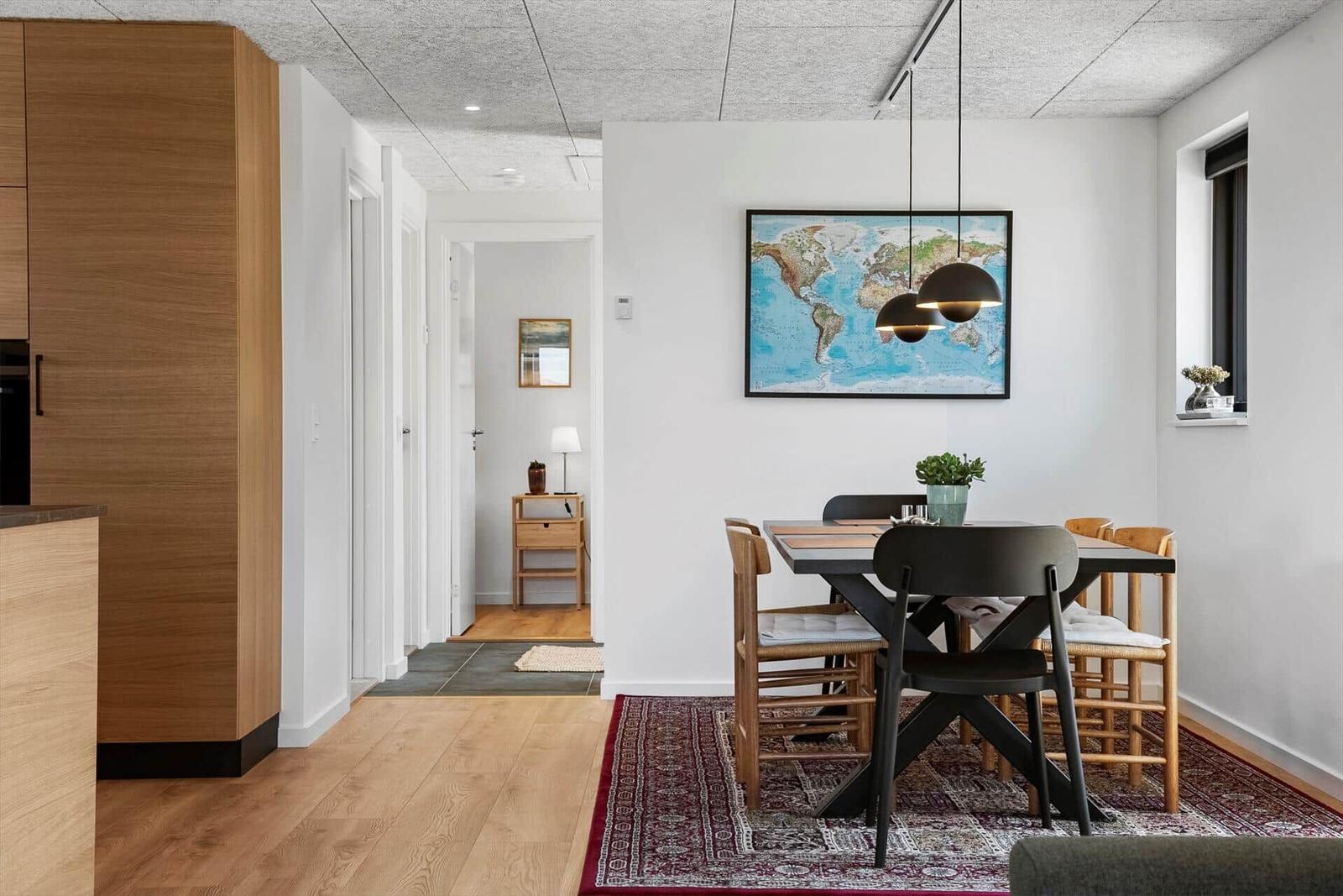 Essbereich mit Tisch, Stühlen und Weltkarte an der Wand.