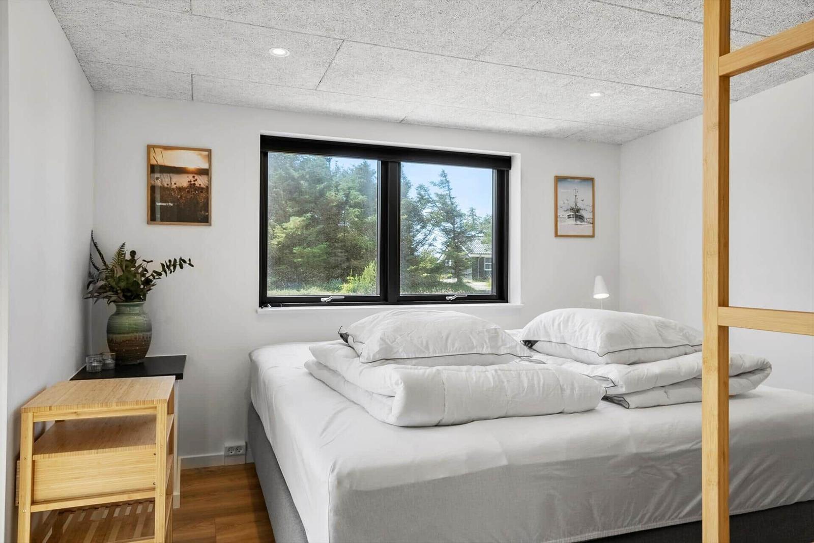 Schlafzimmer mit Bett, Fenster und Holzmöbel