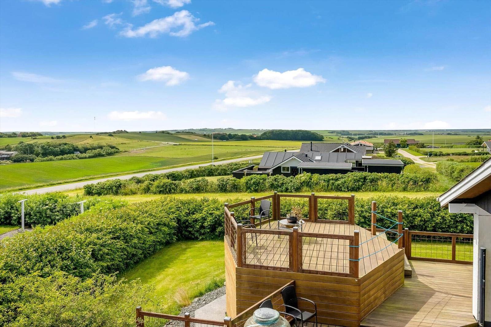 Terrasse mit Sitzgelegenheit und Blick auf grüne Landschaft.