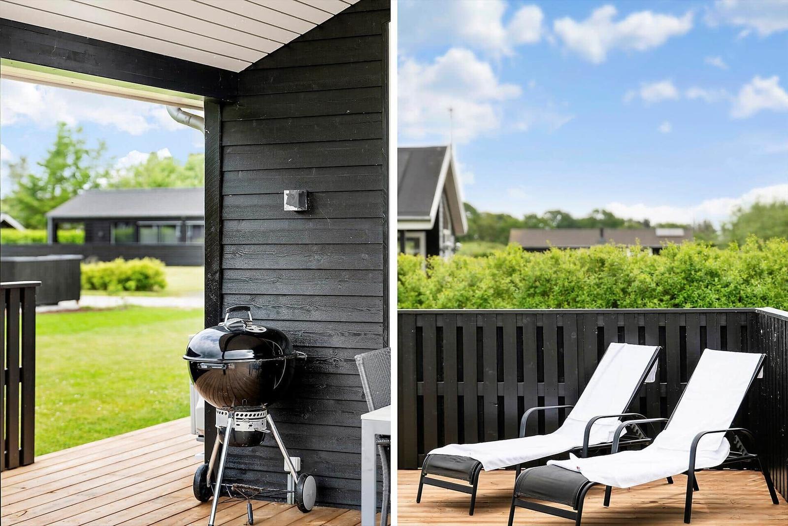 Terrasse mit Grill und Liegestühlen. Blick auf grünen Garten und Himmel.