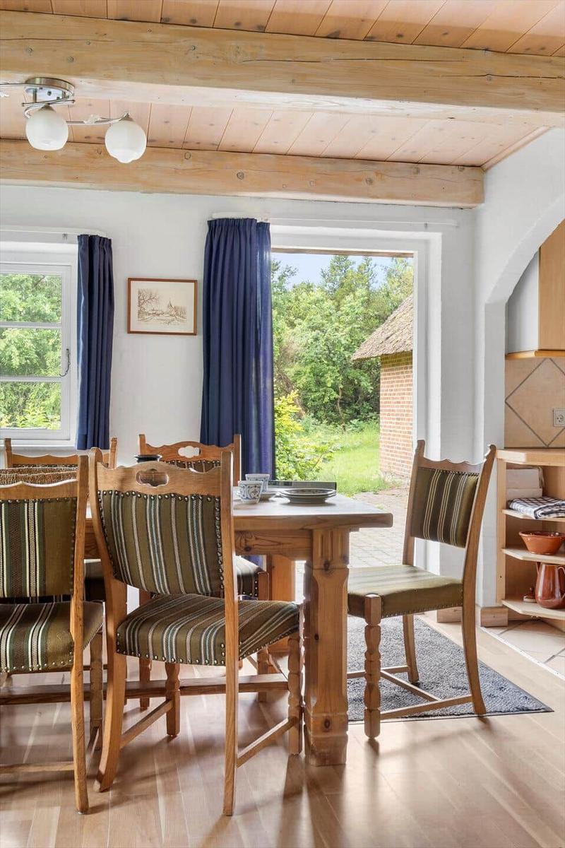 Esszimmer mit Holztisch, Stühlen und Blick auf Garten