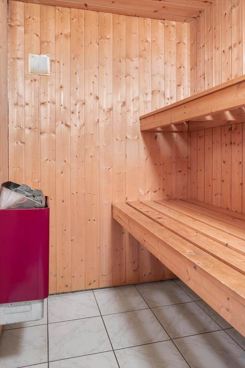 Sauna mit Holzwand, Sitzbänken und Heizung