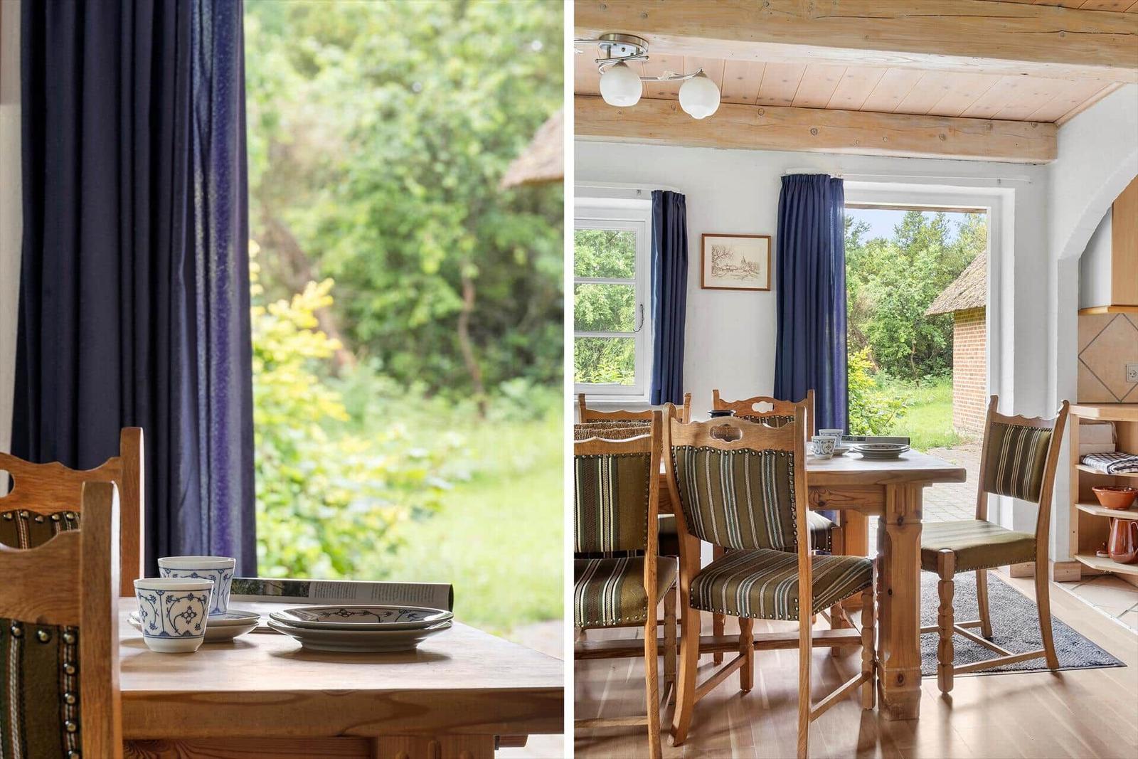 Holztisch mit Stühlen, blauen Vorhängen und Blick auf Garten.