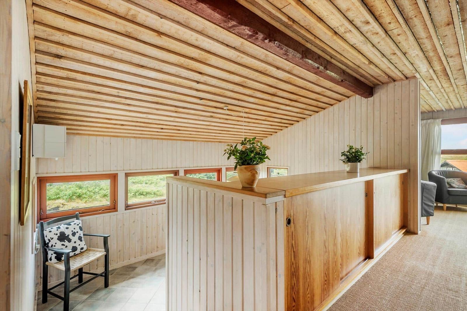 Holzgetäfelte Wand und Decke mit Sitzgelegenheit und Pflanzen