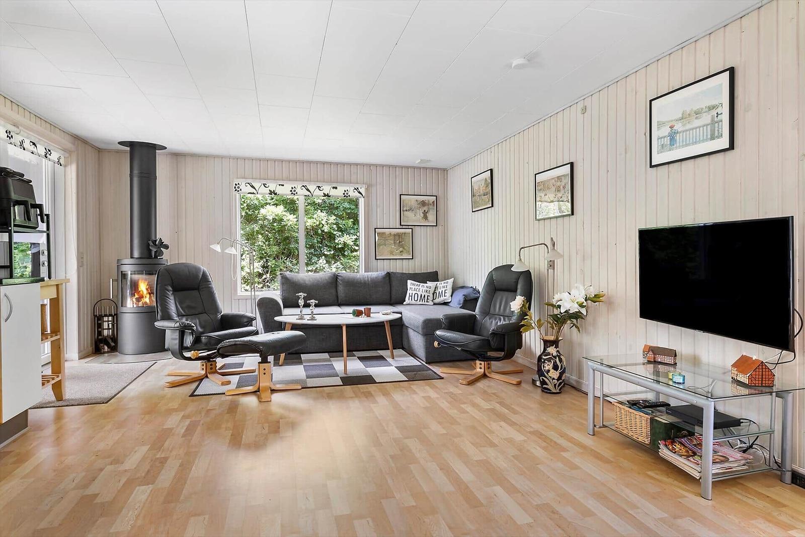 Living room with sofa, two chairs, fireplace, and TV.