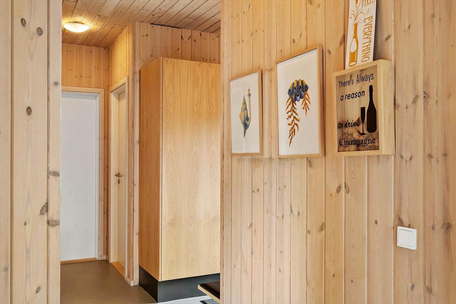Holzwand mit Bildern und Schrank im Flur