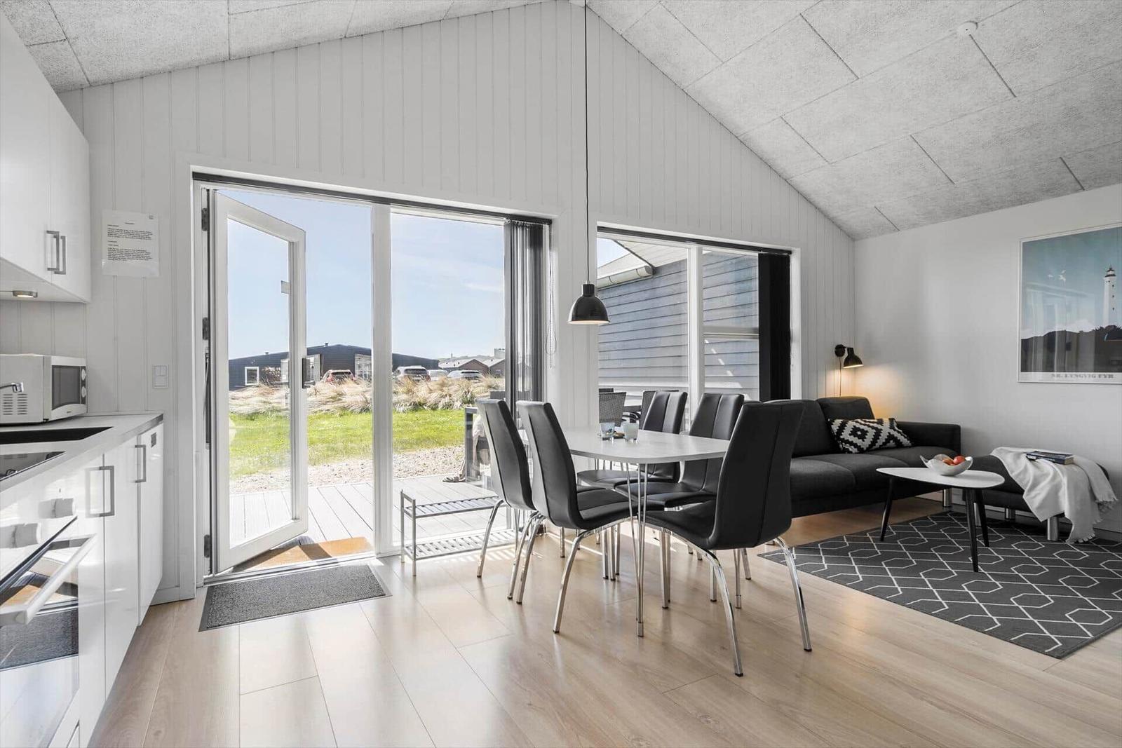 Wohnbereich mit Essbereich, Küche und Terrasse. Moderne Einrichtung mit Blick auf Außenbereich.