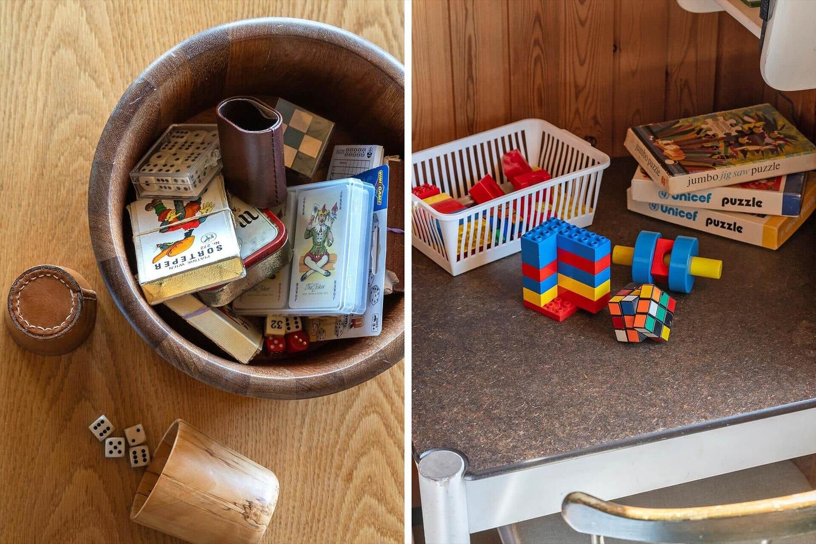 Holztablett mit Spielzeug und Brettspiele, sowie Tisch mit Bausteinen und Puzzles.