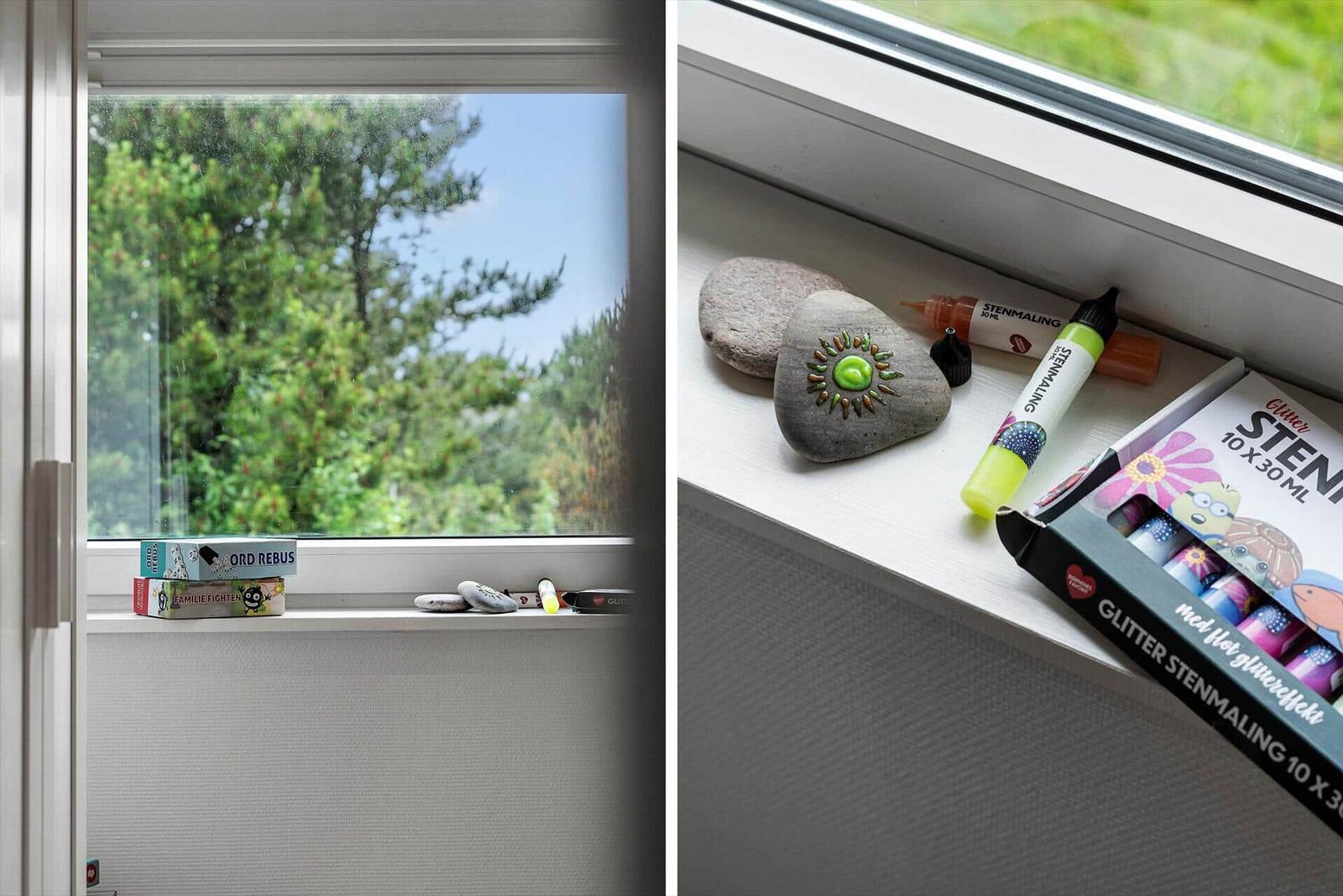 Fensterblick auf Bäume, Spielzeug und Steine auf dem Fensterbrett.
