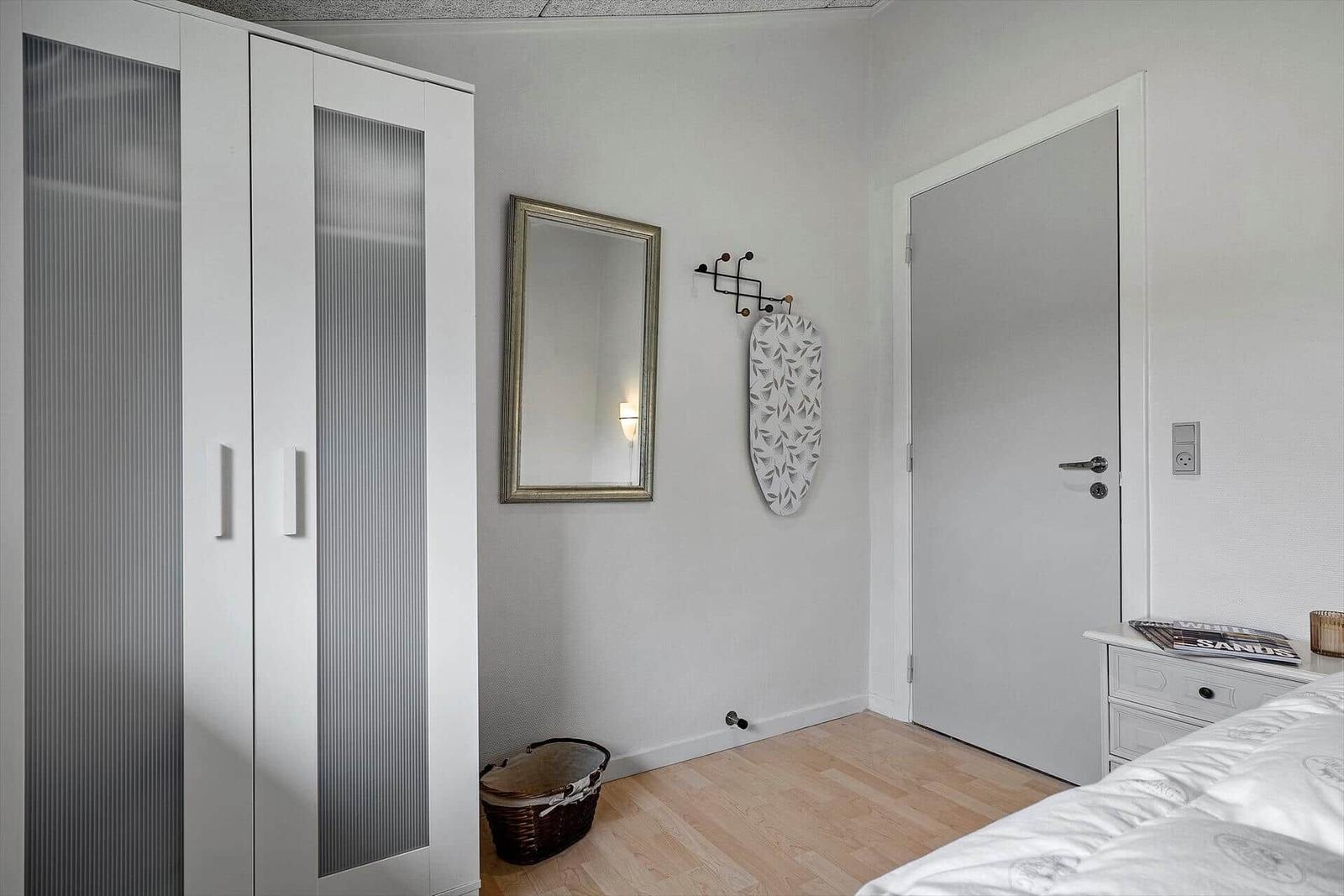 Schlafzimmer mit Kleiderschrank, Spiegel und Bett