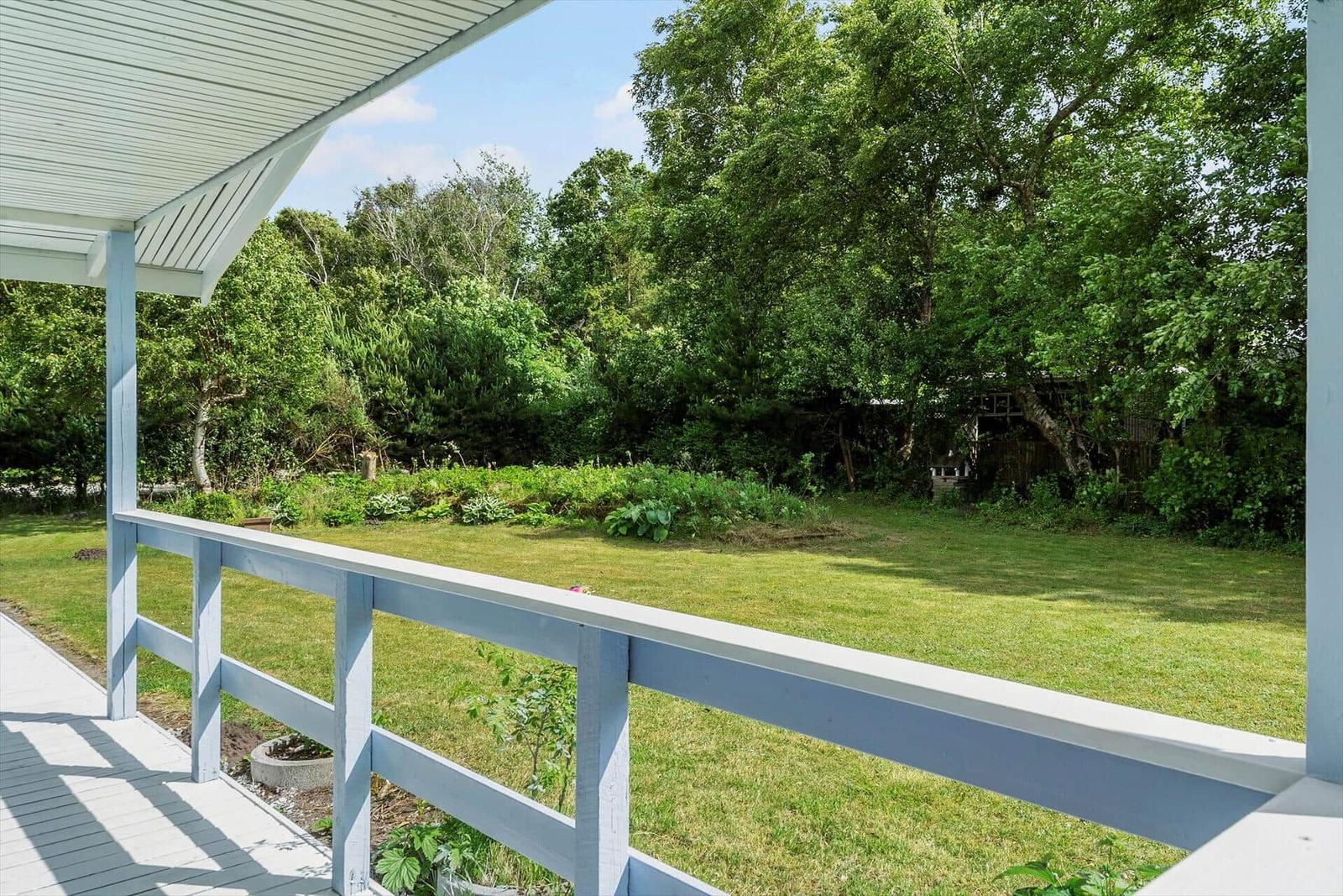 Terrasse mit Blick auf grünen Garten und Bäume