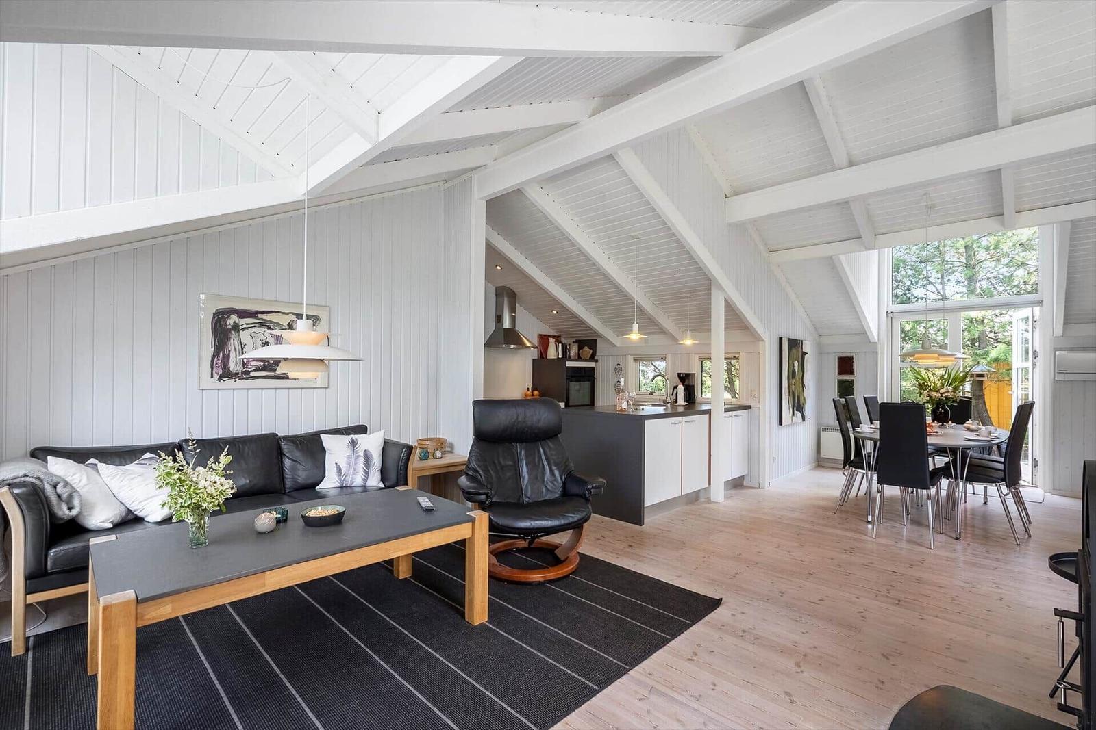 Wohnzimmer mit Essbereich und Küche unter hohem Dach