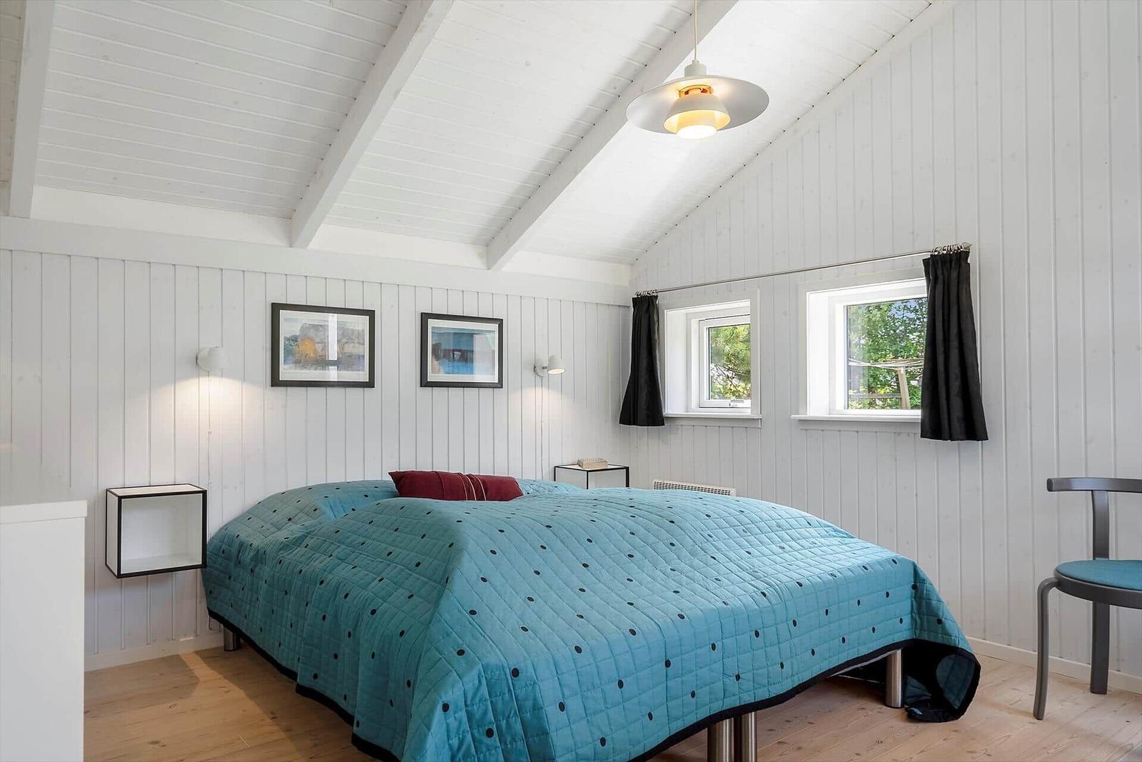 Schlafzimmer mit Bett, Fenstern und Decke.