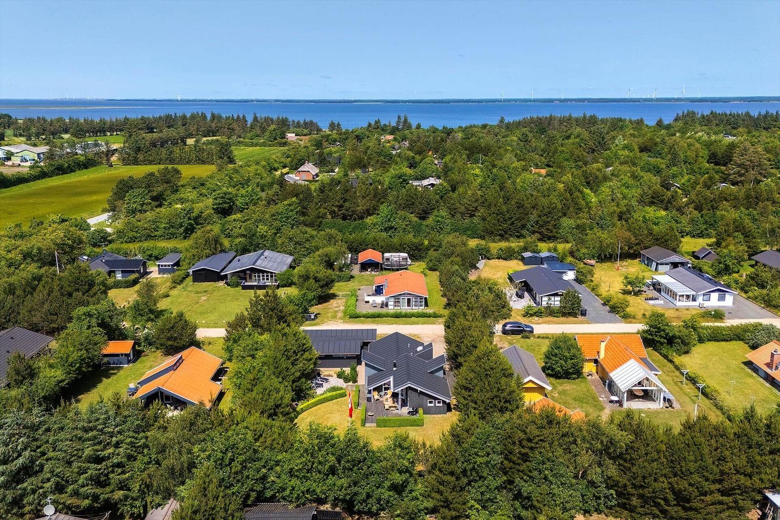 Ländliche Ferienhäuser mit Blick aufs Meer und Windkraftanlagen