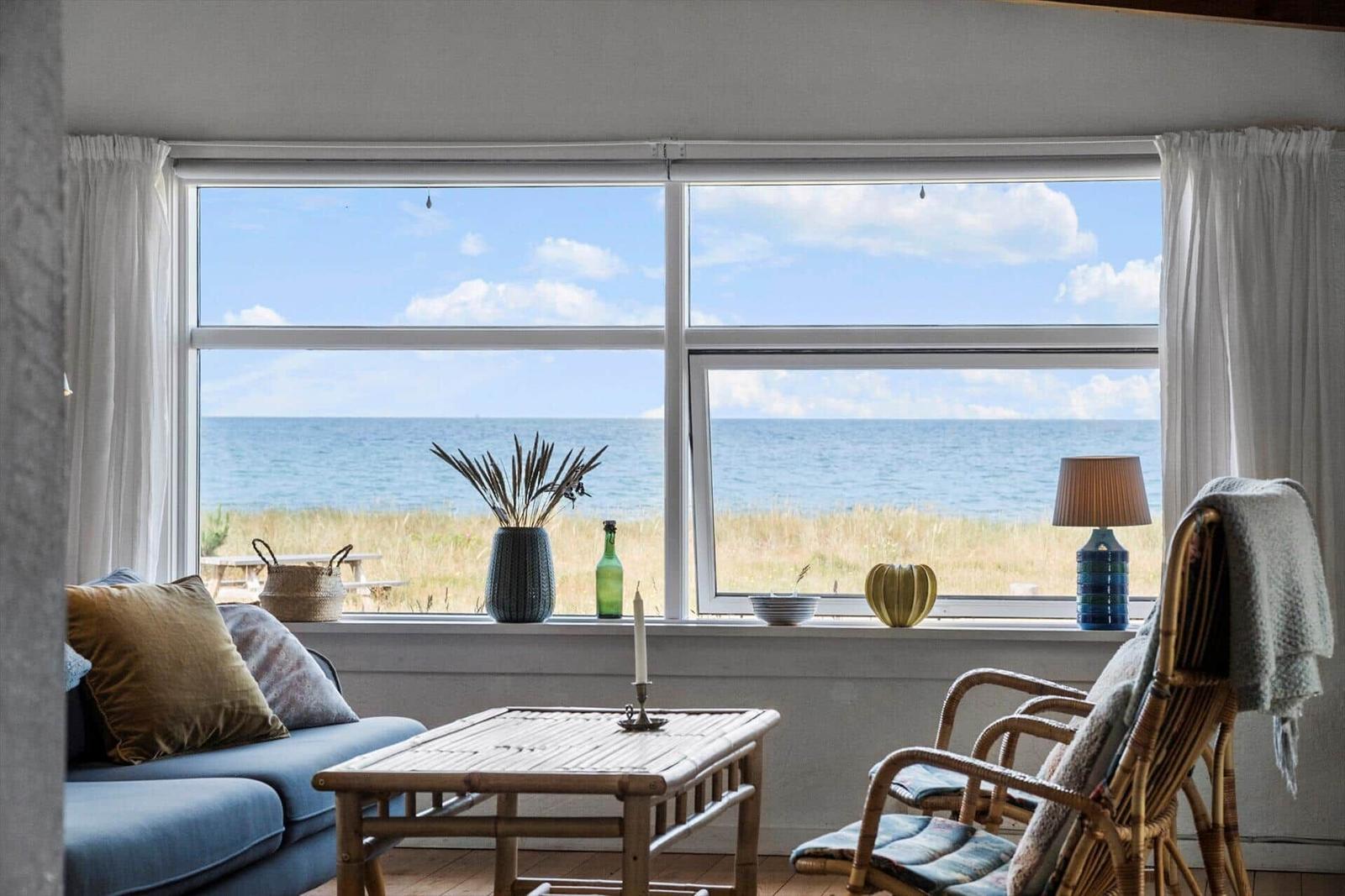 Living room with sea view. Furniture and decor are on the windowsill.
