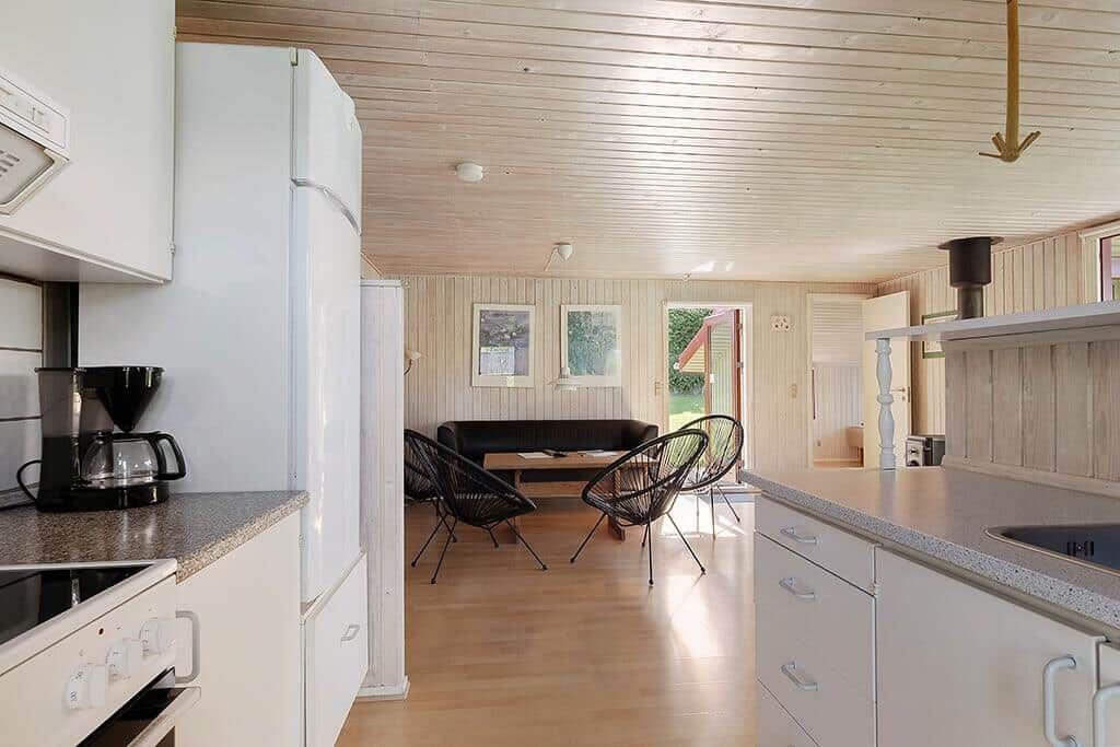 Küche mit Essbereich und Wohnzimmer mit Sofa und Stühlen