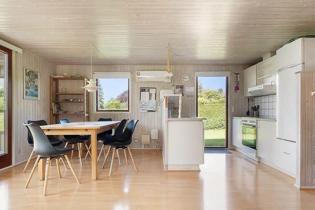 Küche und Essbereich mit Tisch, Stühlen und Blick auf Garten