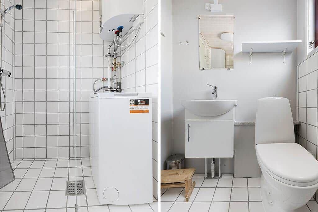Badezimmer mit Dusche, Waschbecken und Toilette. Weiße Fliesen und moderne Einrichtung.