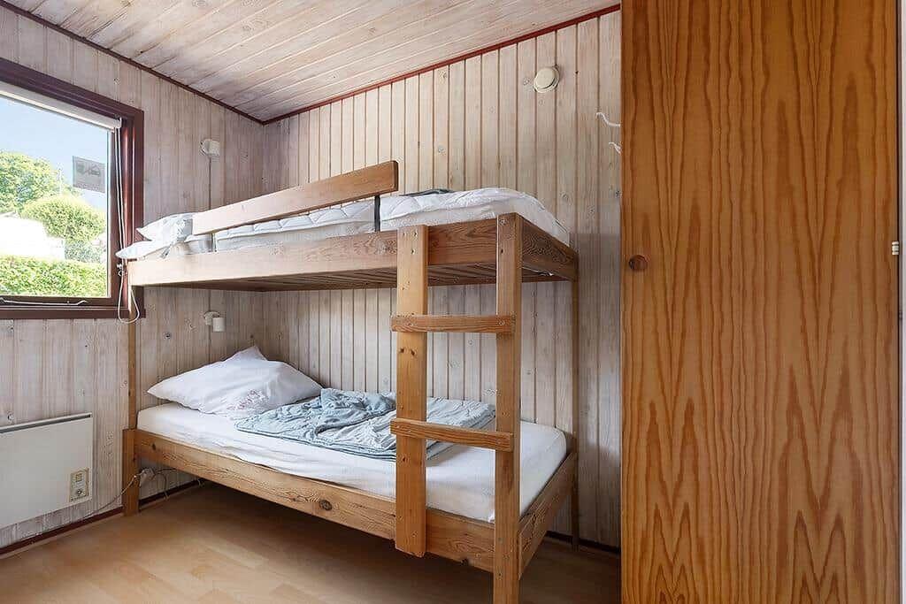 Zimmer mit Holzbett und Fenster zur Aussicht