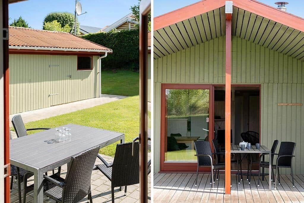 Terrasse mit Tisch und Stühlen vor einem Holzhaus mit rotem Dach.