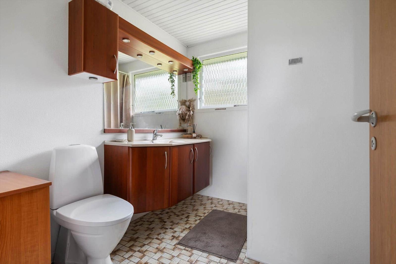 Badezimmer mit Toilette, Waschbecken und Spiegel