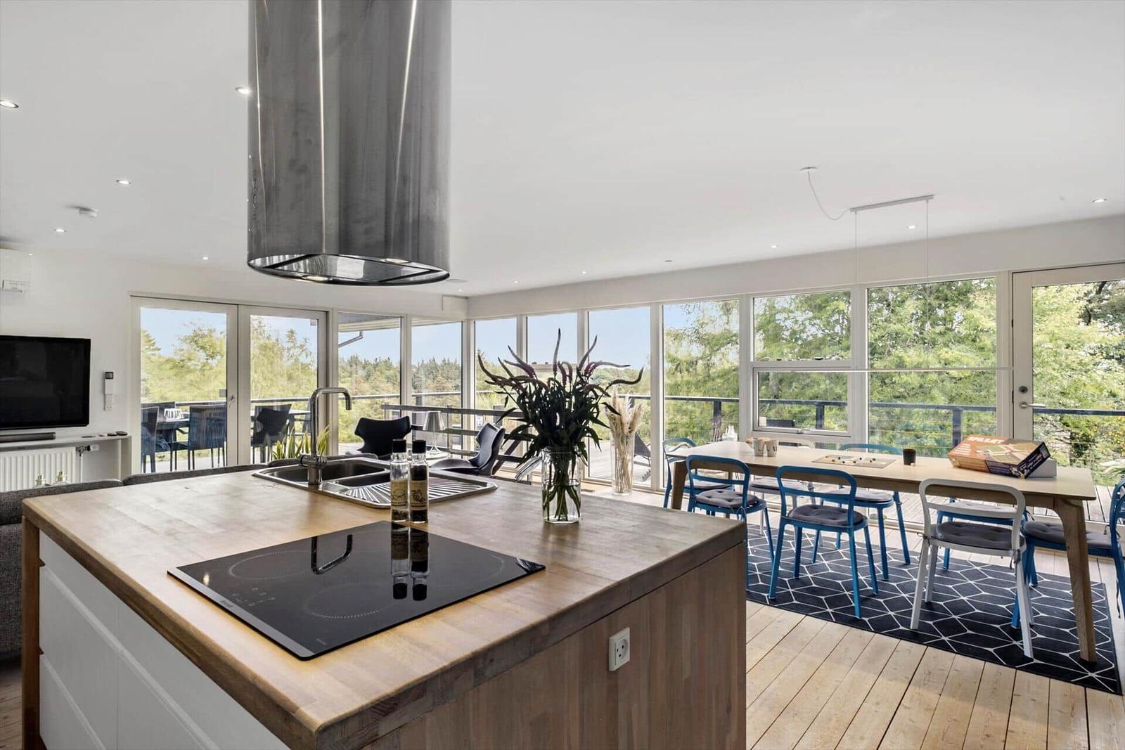 Kitchen with island, dining area, and large window view of the outdoor terrace.