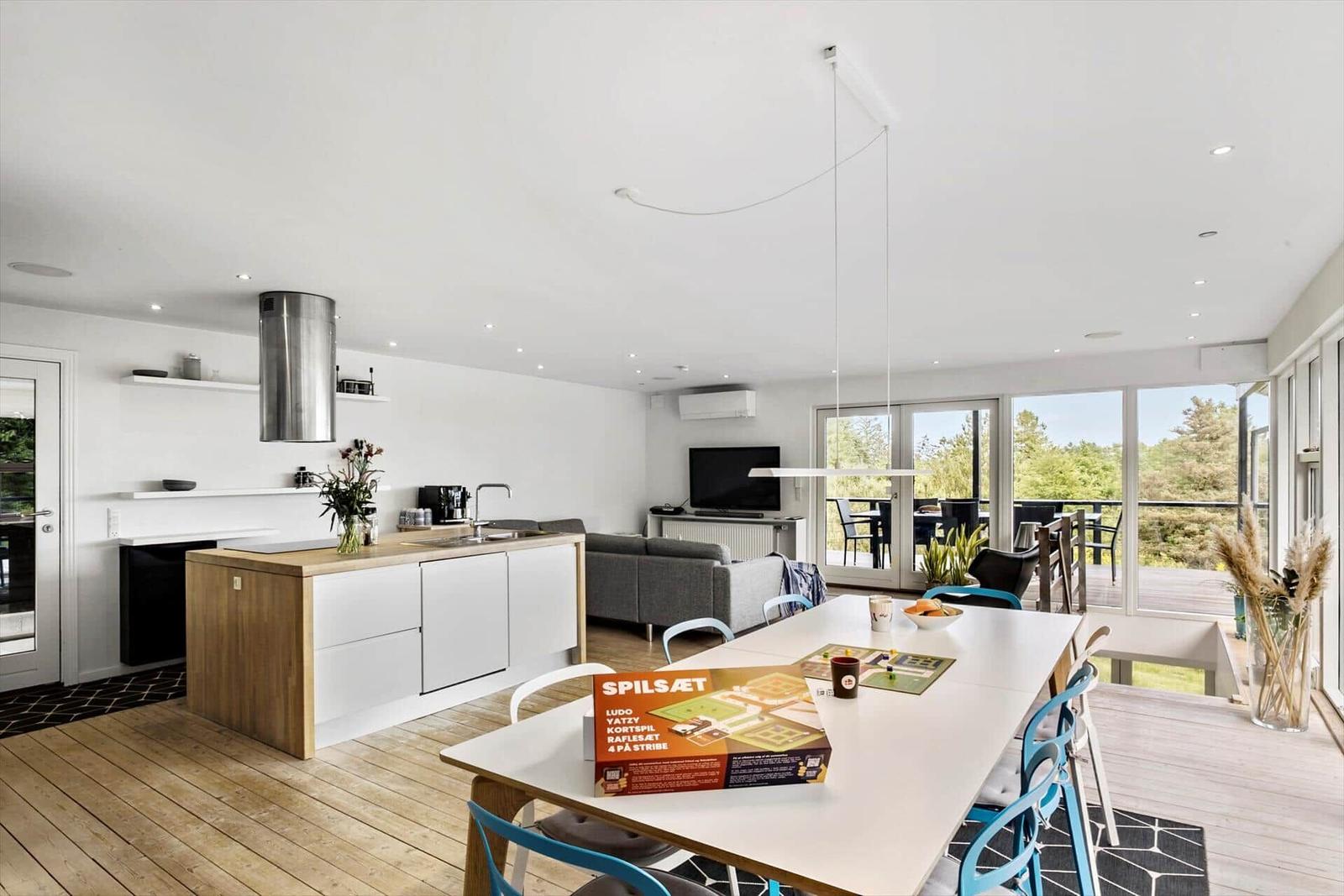 Modern kitchen with dining area and view of balcony.