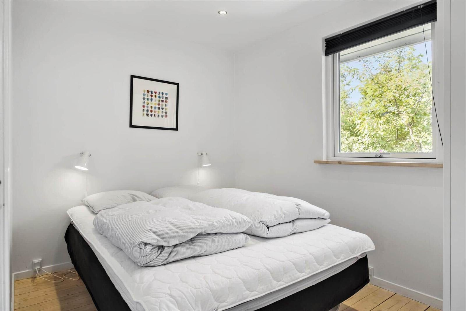 Bedroom with bed, window, and wall art.