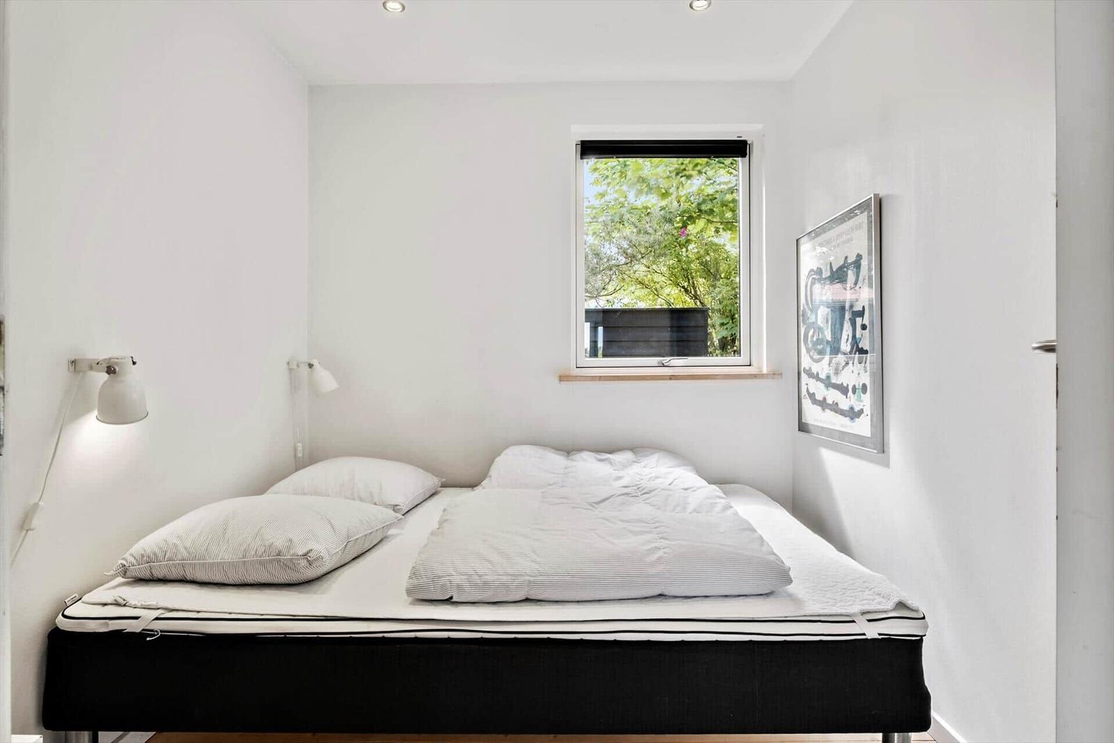 Bedroom with bed, window, and wall art.