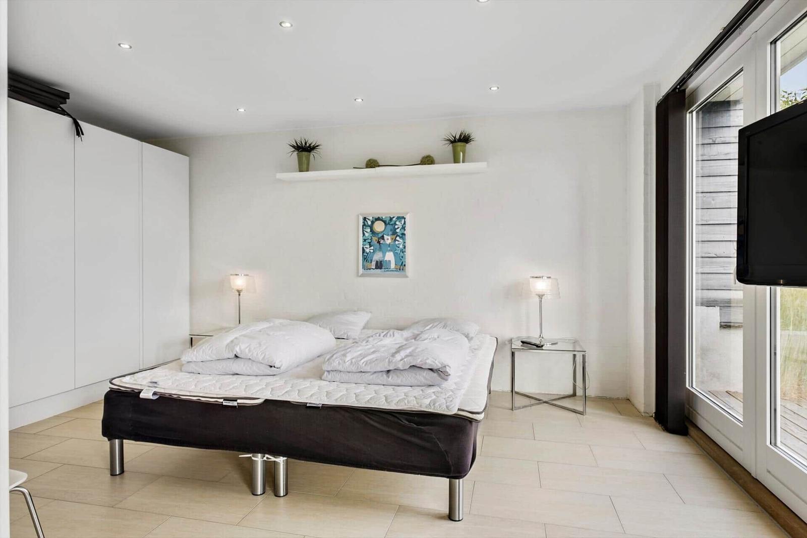 Bedroom with bed, nightstands, and window.