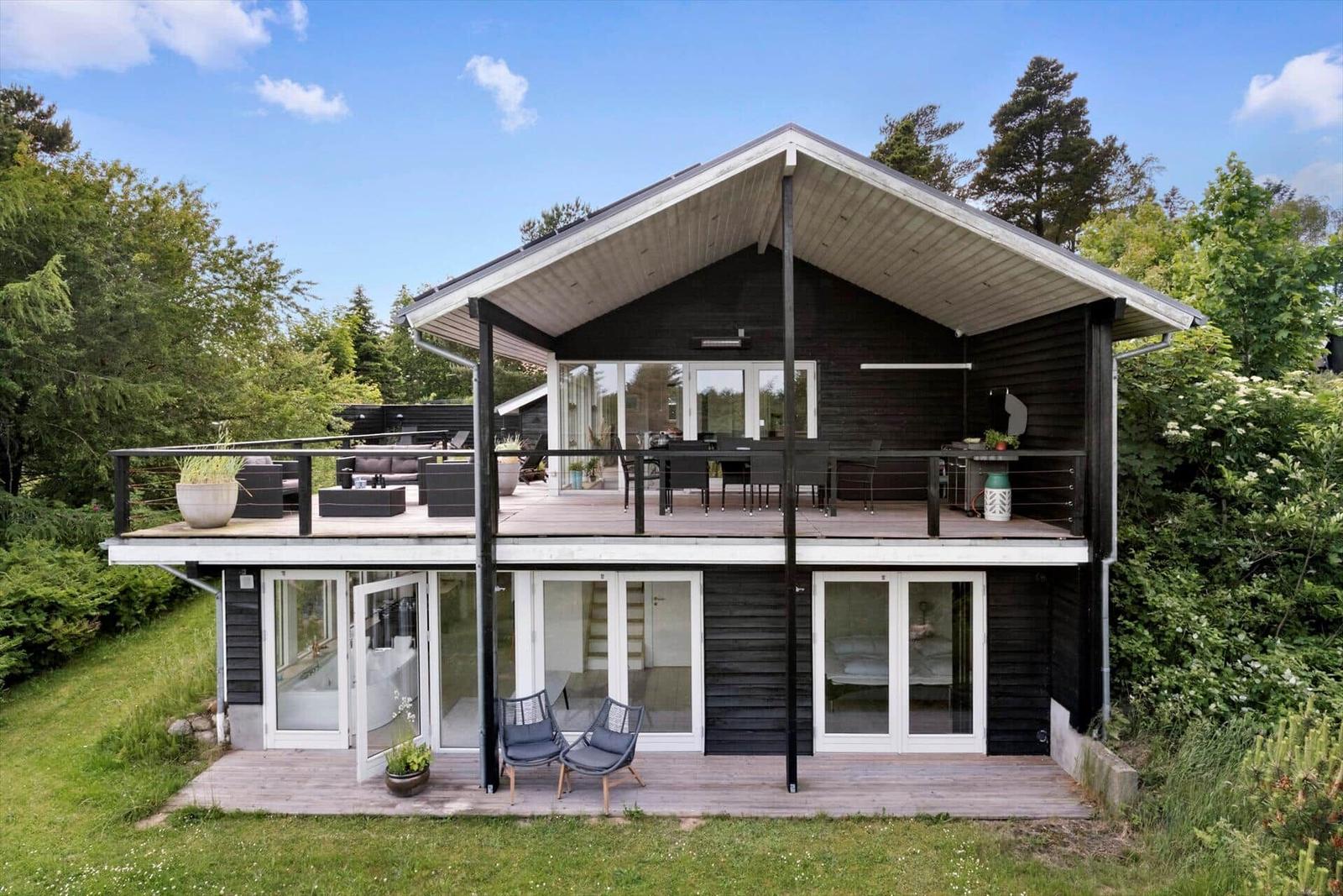 Modern house with terrace and garden. Large windows and balcony.