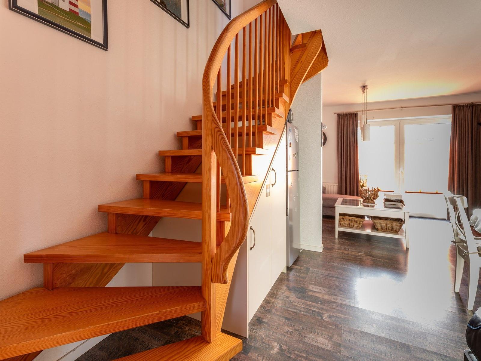 Holztreppenhaus mit Blick in Wohn- und Essbereich
