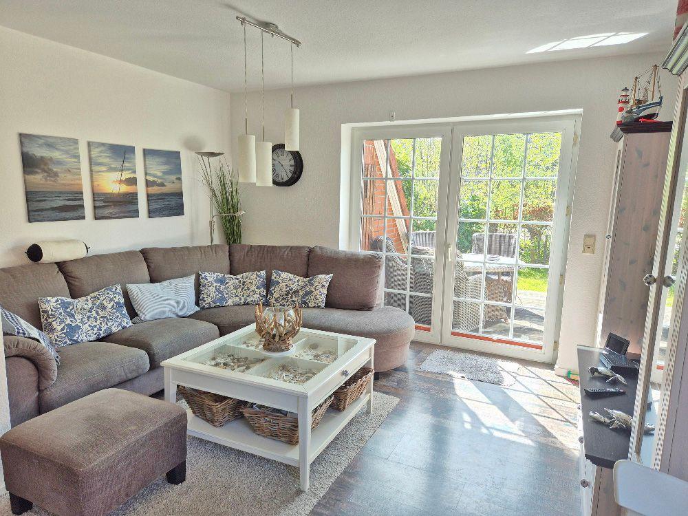 Wohnzimmer mit Sofa, Couchtisch und Glastür zum Garten.