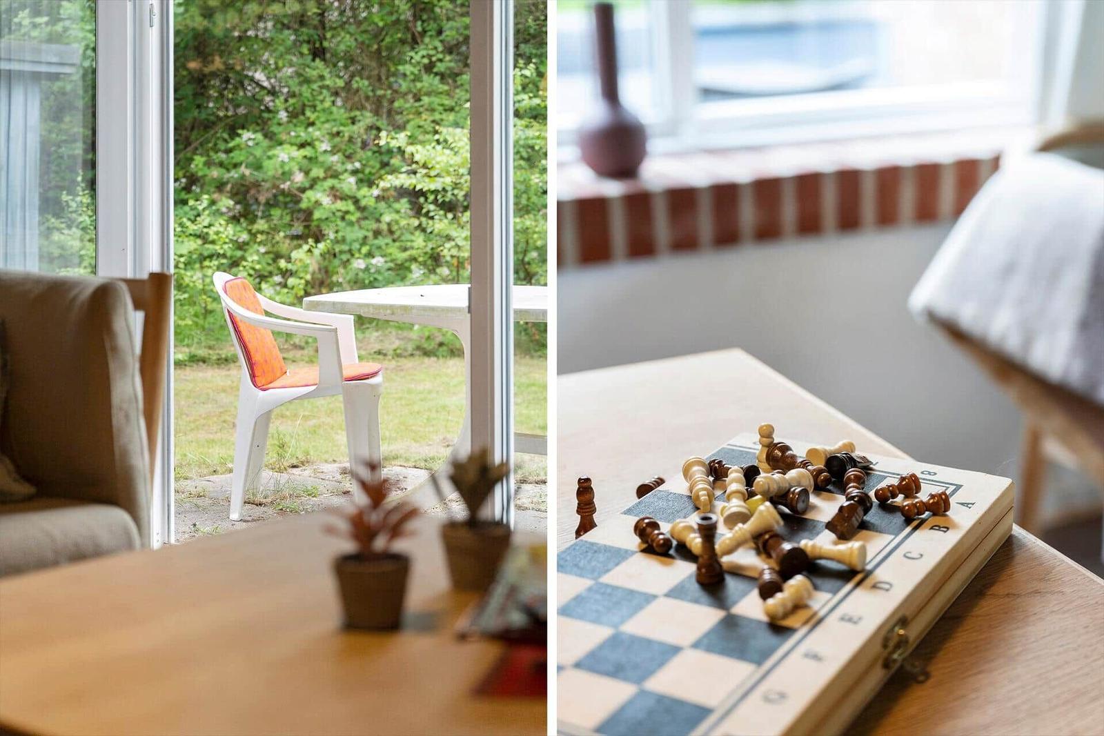 Terrasse mit Stuhl und Tisch. Schachbrett mit Figuren auf Tisch.