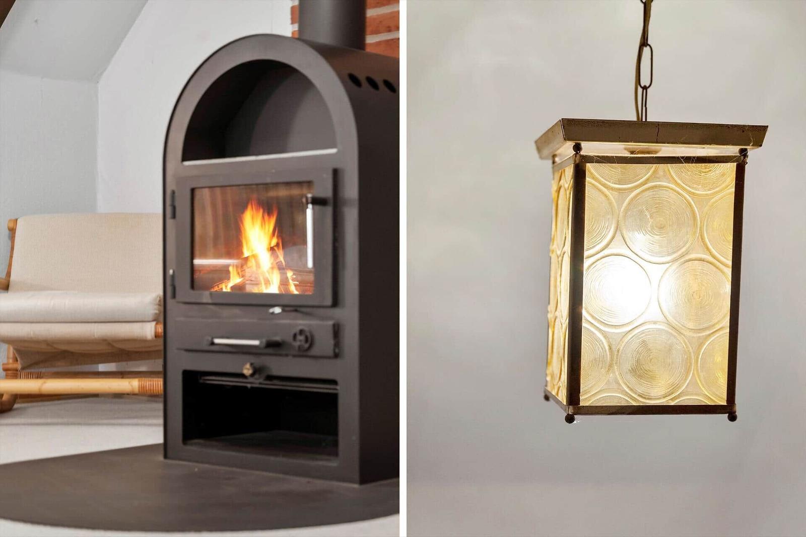 Kaminofen mit brennendem Feuer und hängende Lampe mit runden Glaspaneelen.