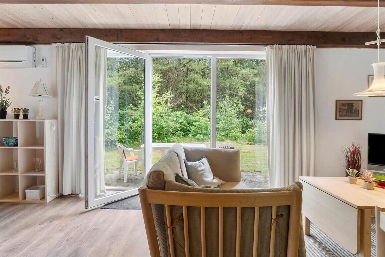 Wohnraum mit Sofa, Esstisch und Blick auf Garten