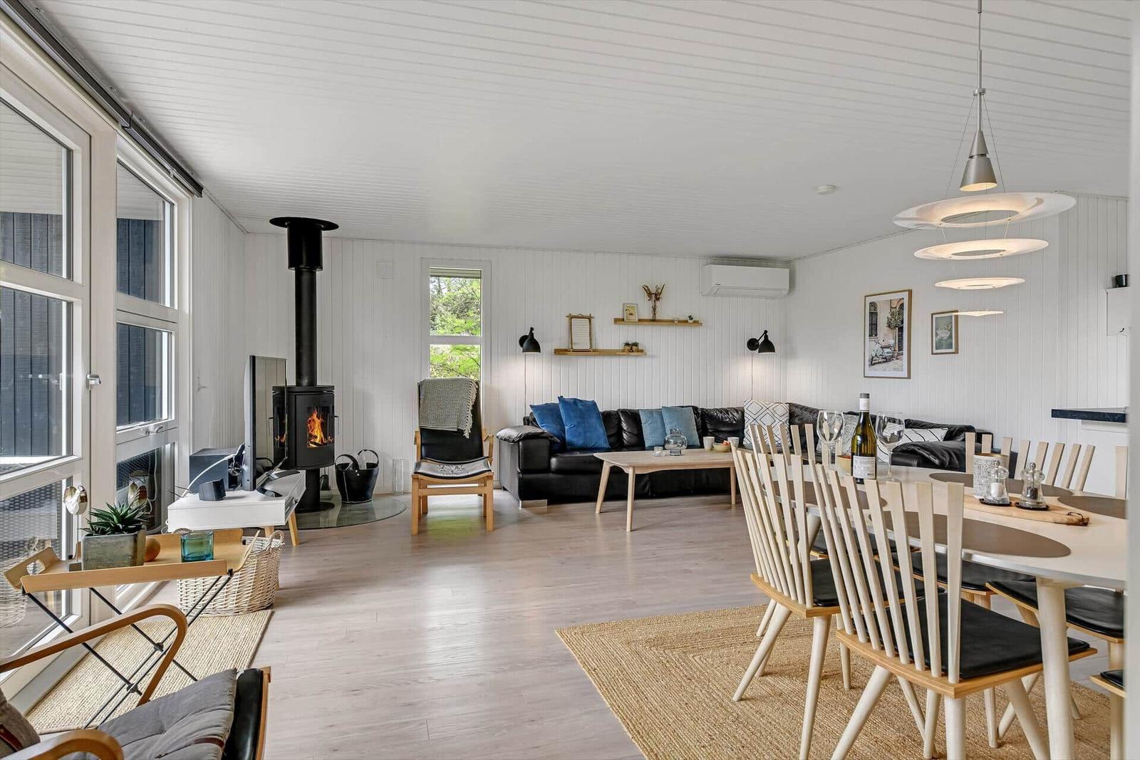 Wohn- und Essbereich mit Kamin, Sofa und Esstisch.
