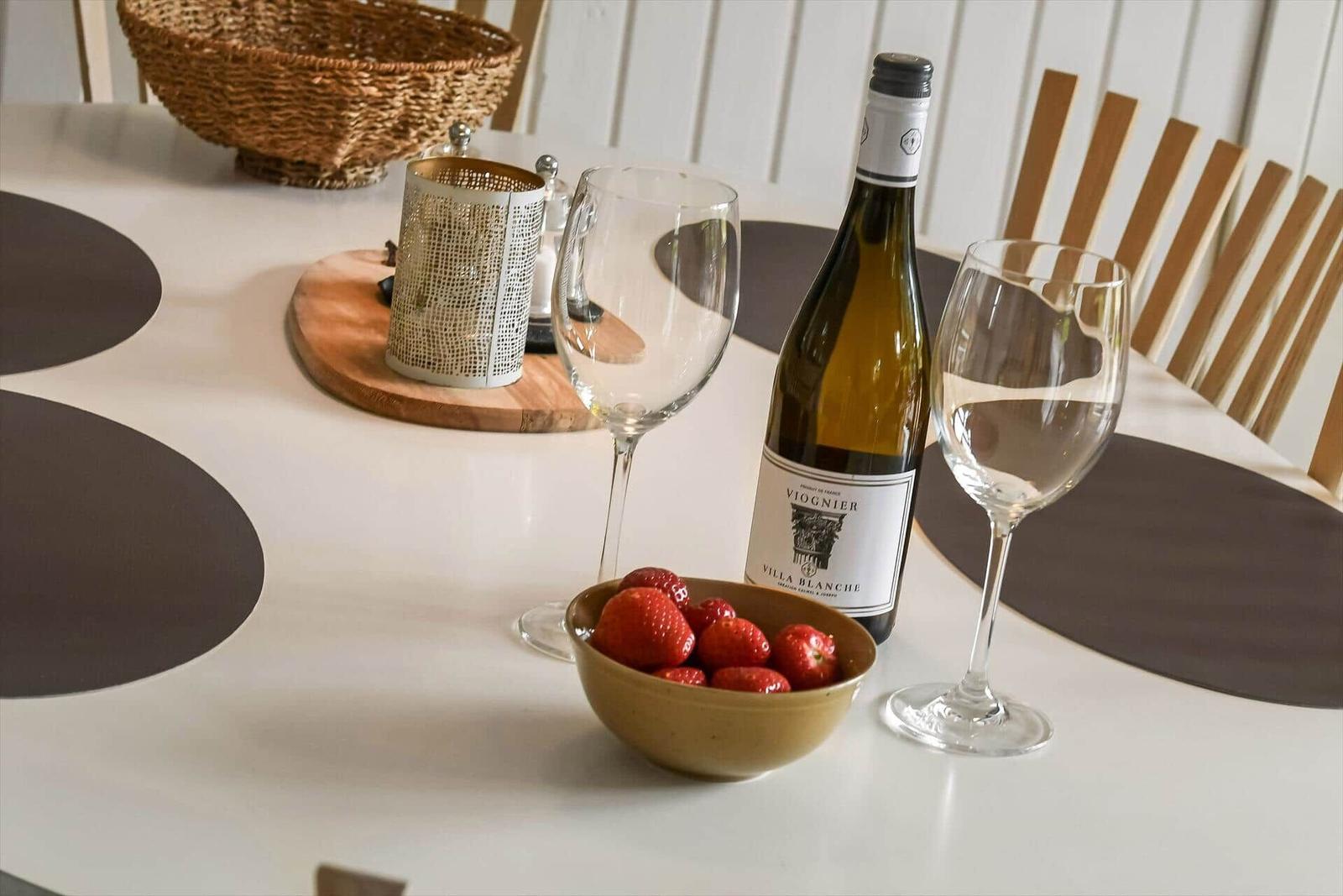 Tisch mit Weinflasche, Gläsern und Erdbeeren