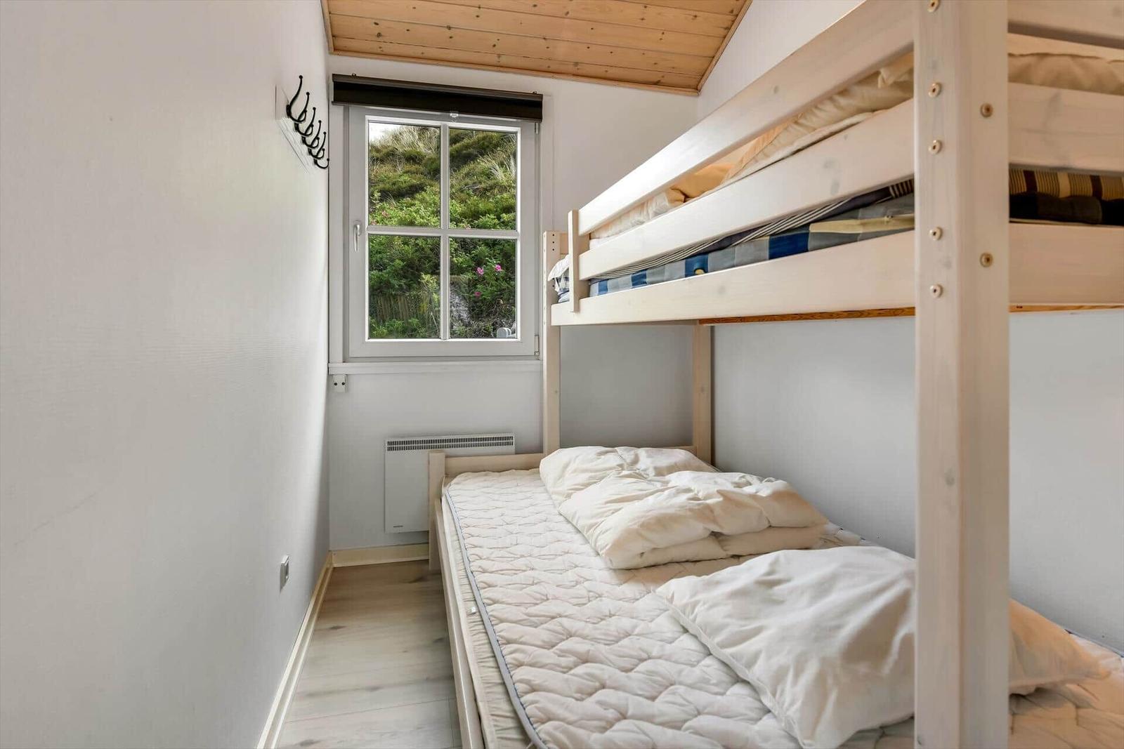Room with bunk bed and window to the garden.