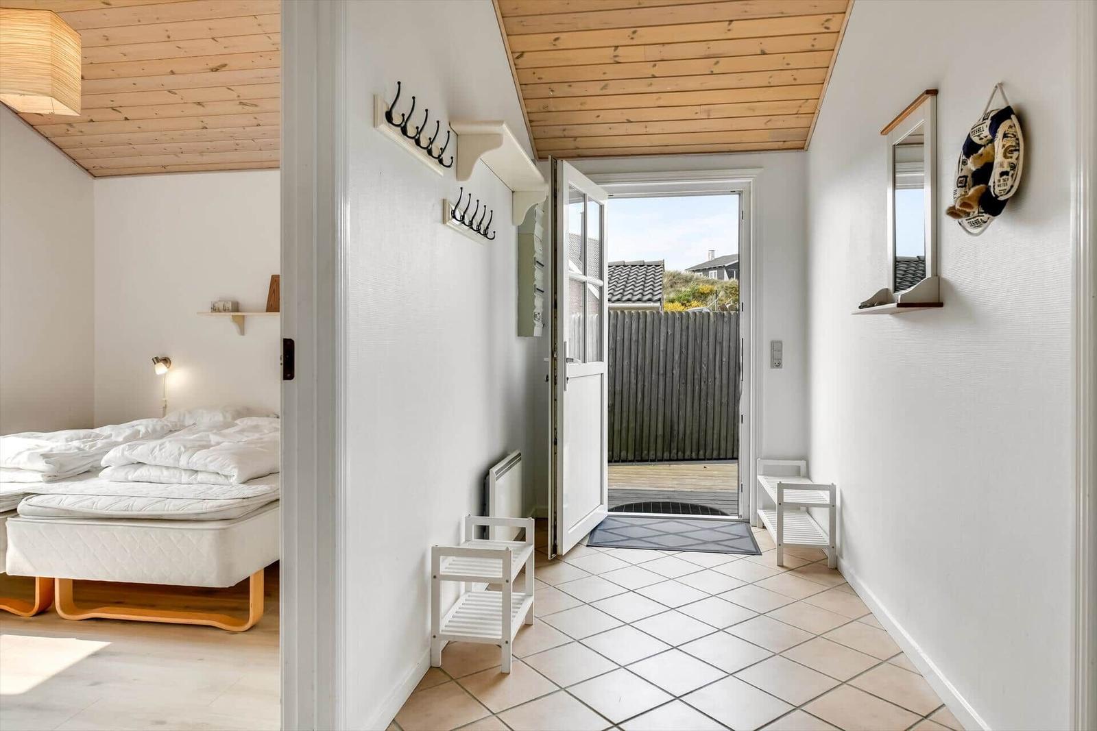 Hallway with door to terrace and view into bedroom with mattress.