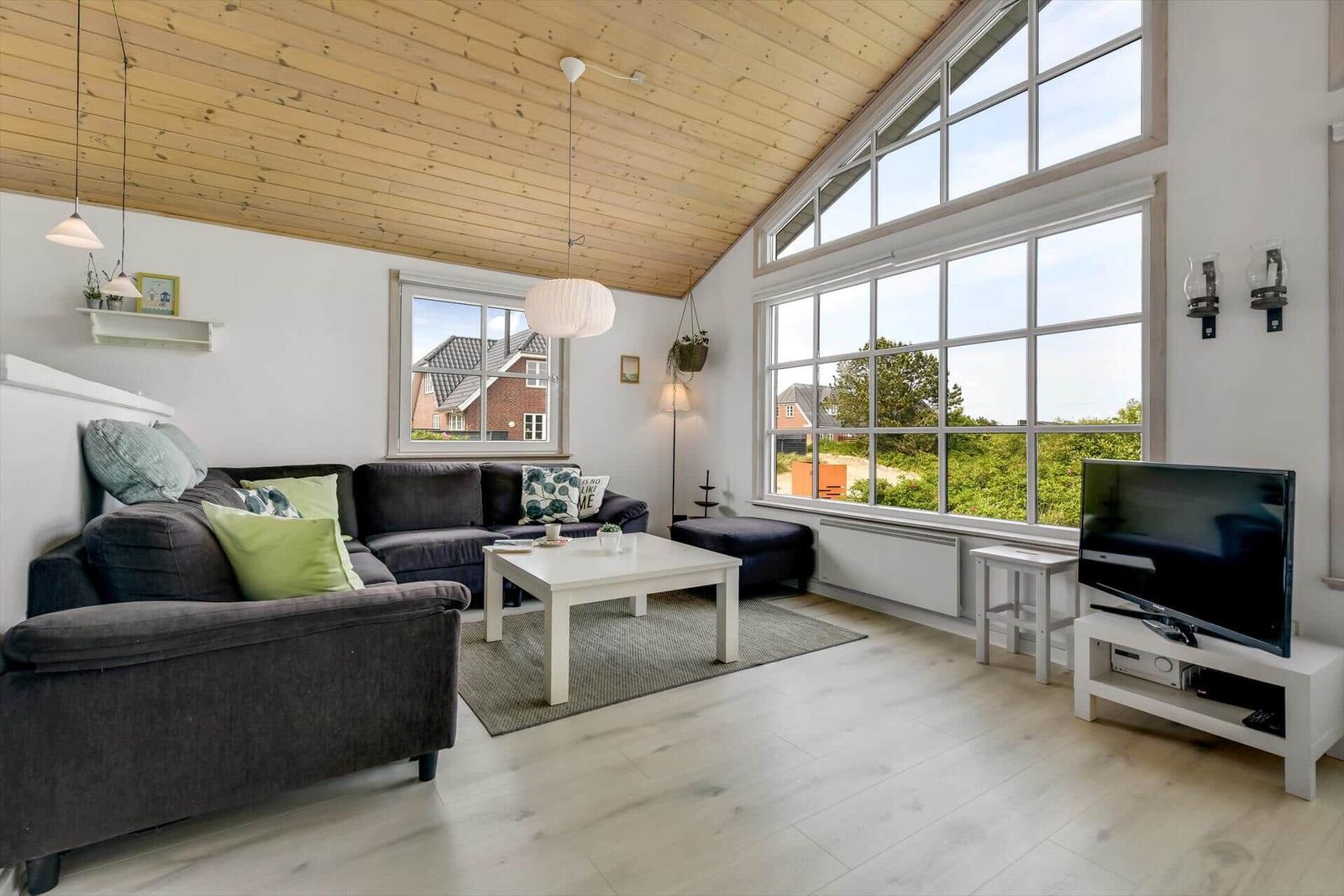 Living room with sofa, coffee table, and large windows.