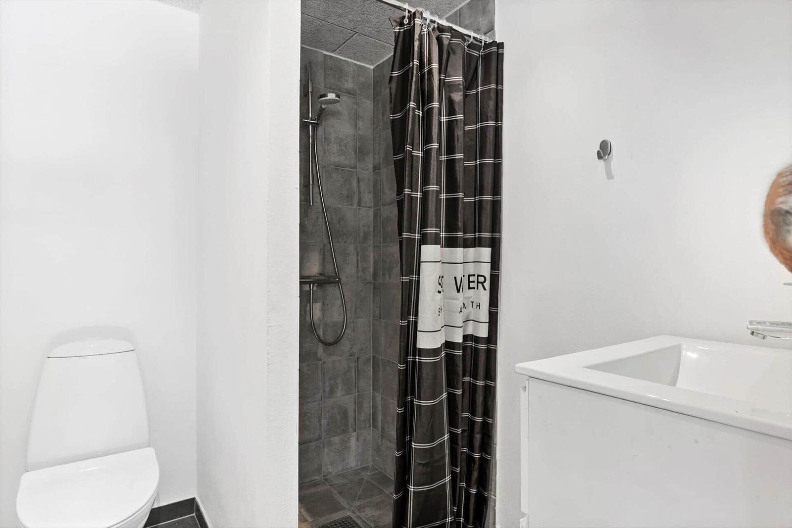 Badezimmer mit Dusche, Toilette und Waschbecken