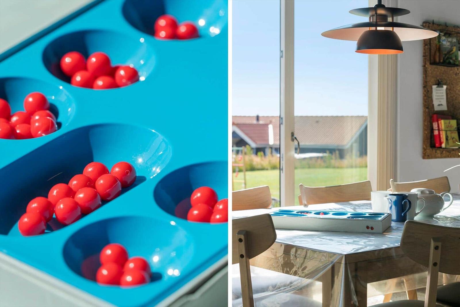 Esszimmer mit Blick auf Garten und Spielplatte mit roten Kugeln.
